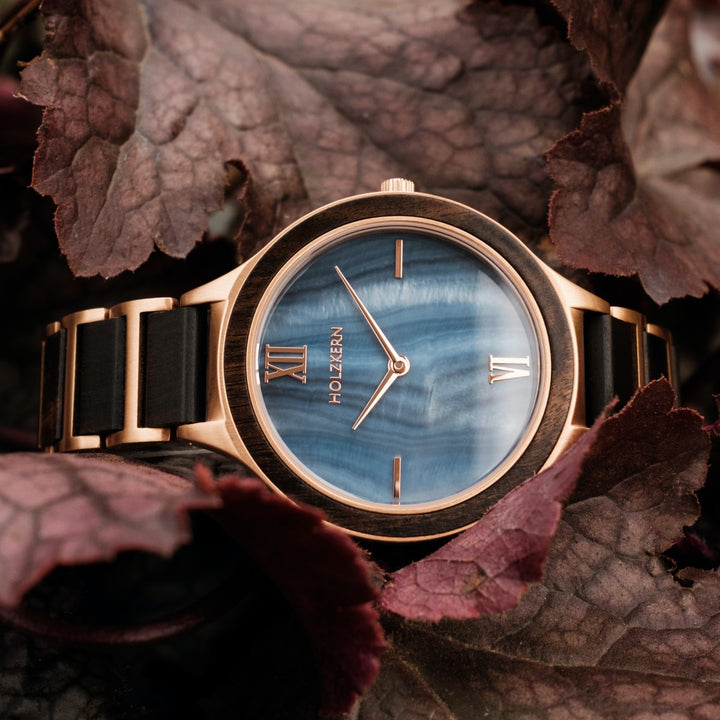 "Maui", a stylish wristwatch, features a unique maple and nacre design with an elegant blue dial and brown strap.