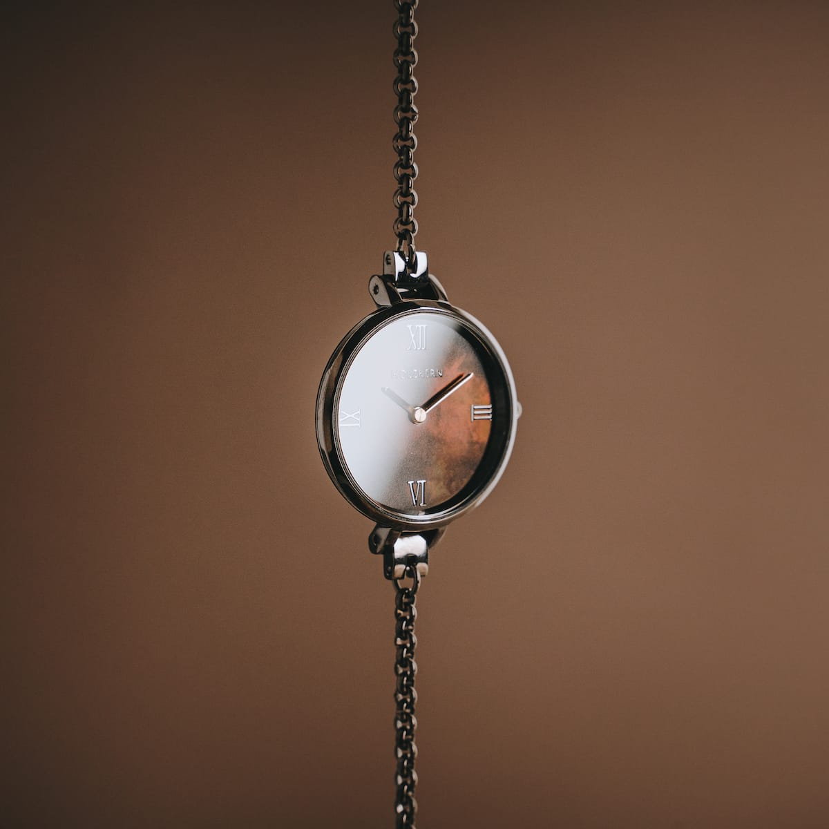 "Élisa" watch in nacre and dark grey, featuring a sleek chain and elegant design.