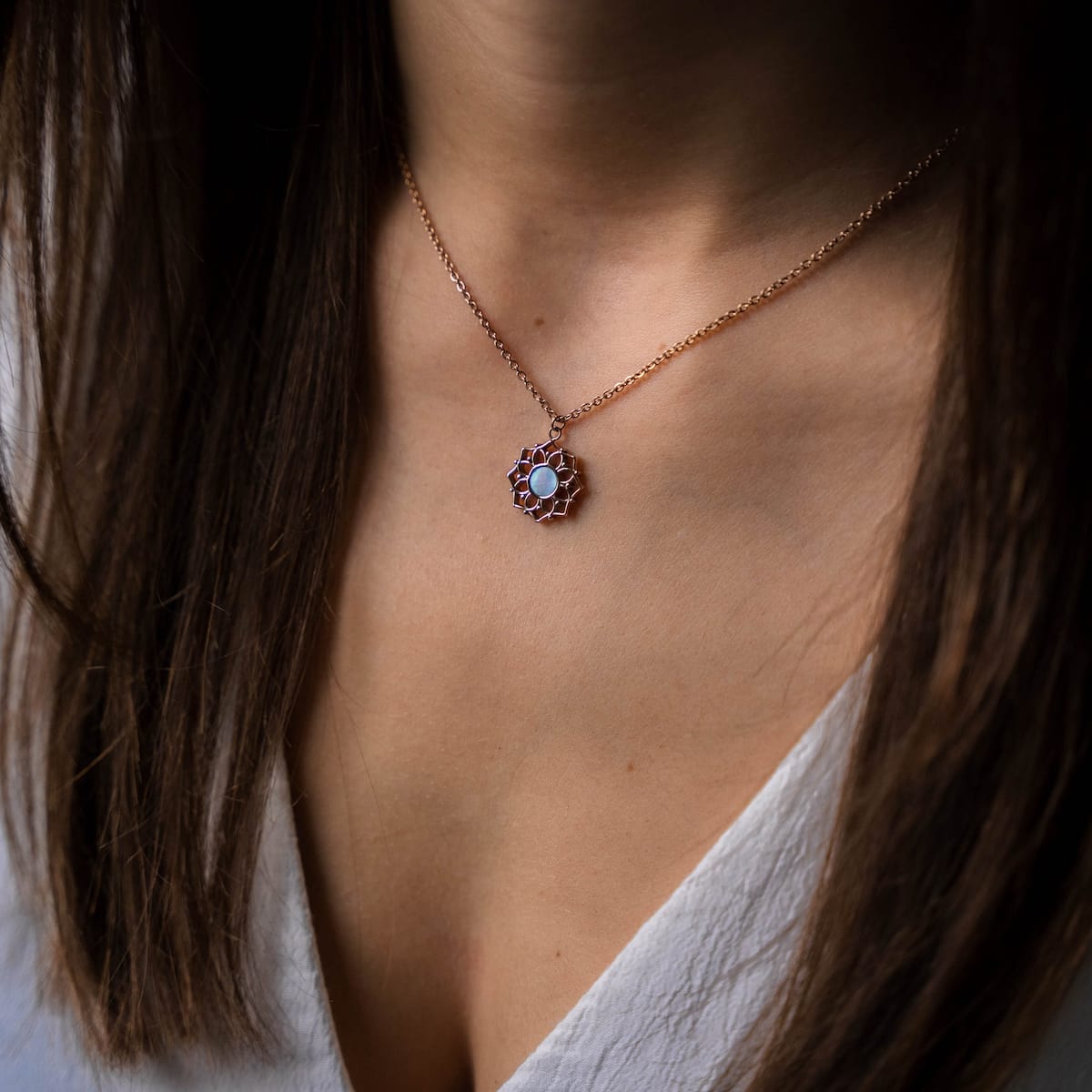 "Composition Necklace": elegant rose gold necklace with blue nacre accent, featuring a stylish and modern design on a woman's neck.