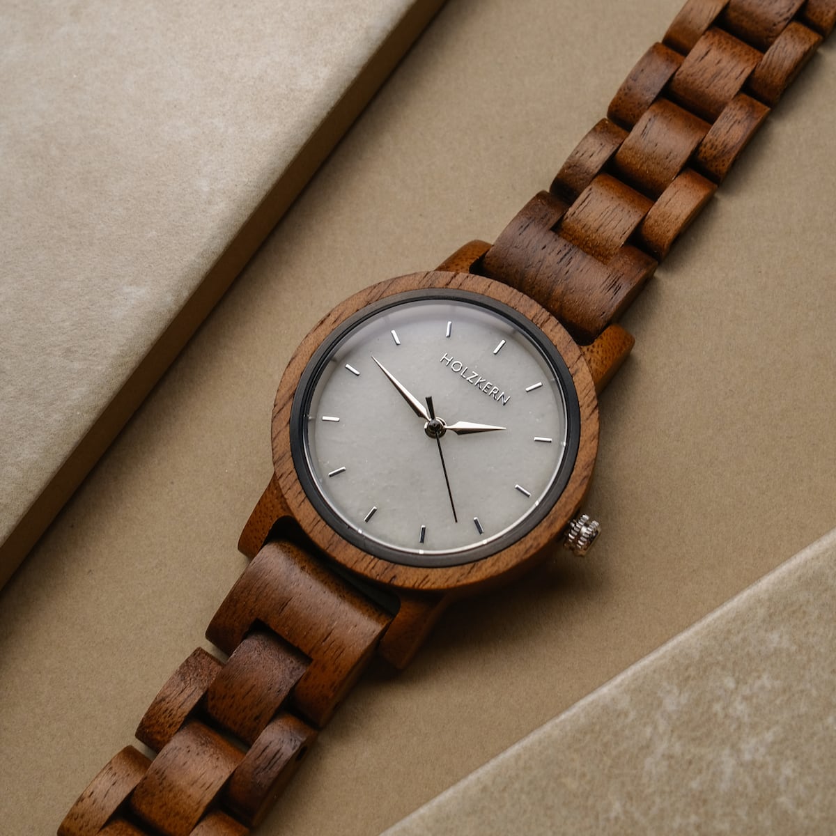 -Air , montre avec une bande de bois de noyer et une face de marbre, mettant en valeur un style élégant et naturel.