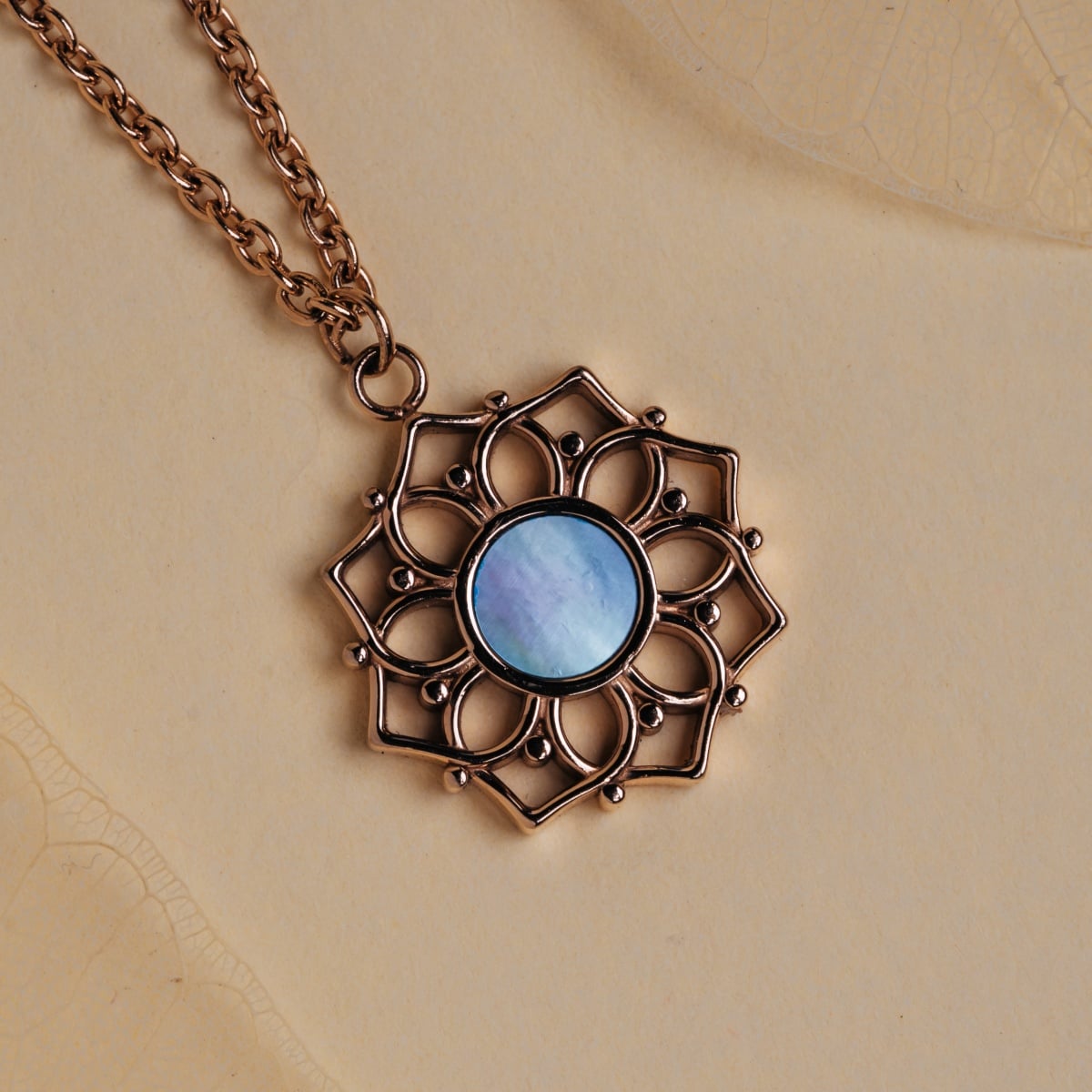 "Composition Necklace" necklace, featuring blue nacre and rose gold, with an intricate floral design.