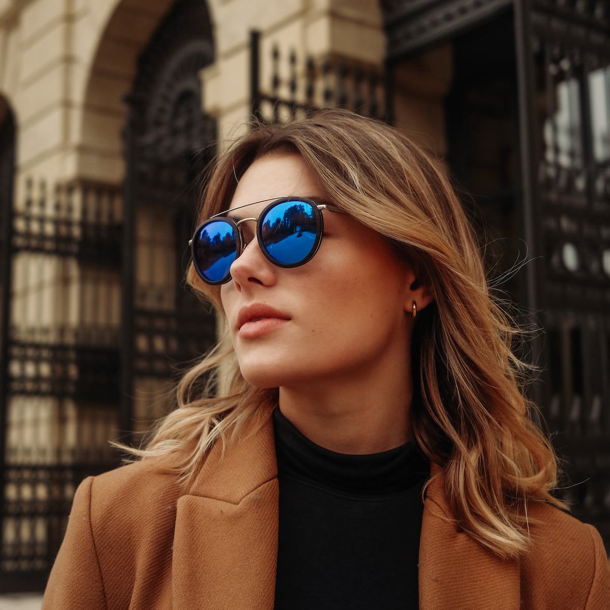 "The Enchanting" sunglasses, featuring a stylish Leadwood and Antique Silver design with striking blue lenses.