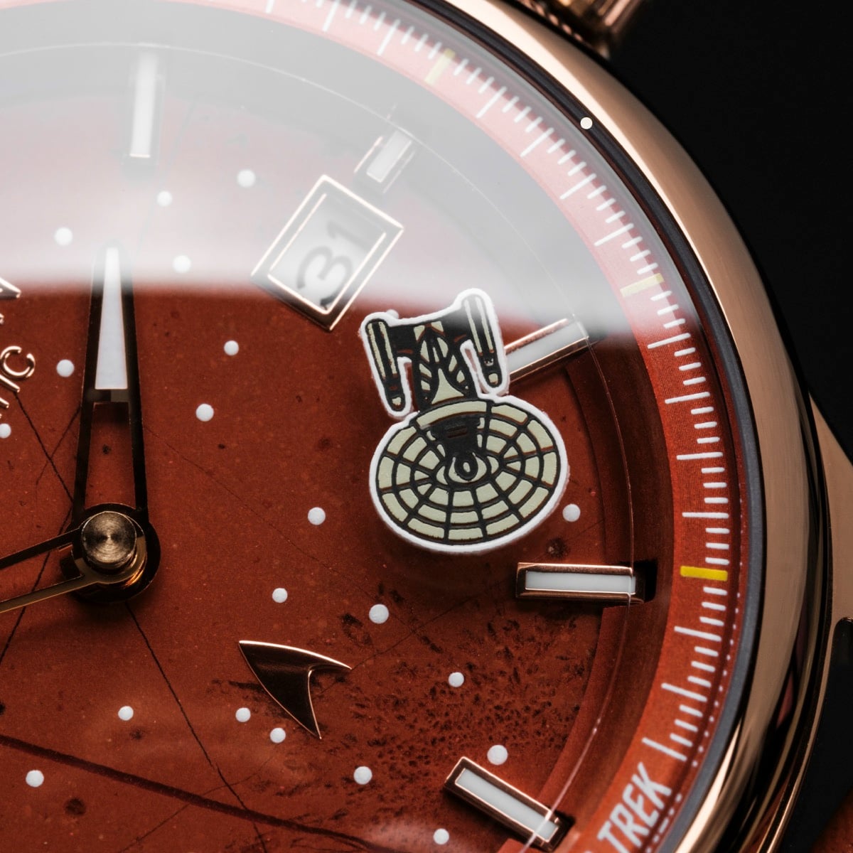 "NCC-1701-D", une montre au design rouge et cuivre, avec des éléments à thème spatial et une apparence élégante.