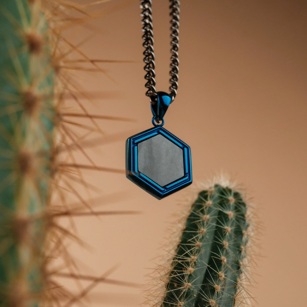 "Axis Necklace" - Hexagonal necklace with a sleek blue and gray design.