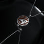 "Operations Necklace" features a round pendant design with jasper and silver accents on a sleek chain.