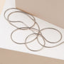 "Charms Necklace", ett elegant silverhalsband med en minimalistisk och elegant design mot en neutral bakgrund.