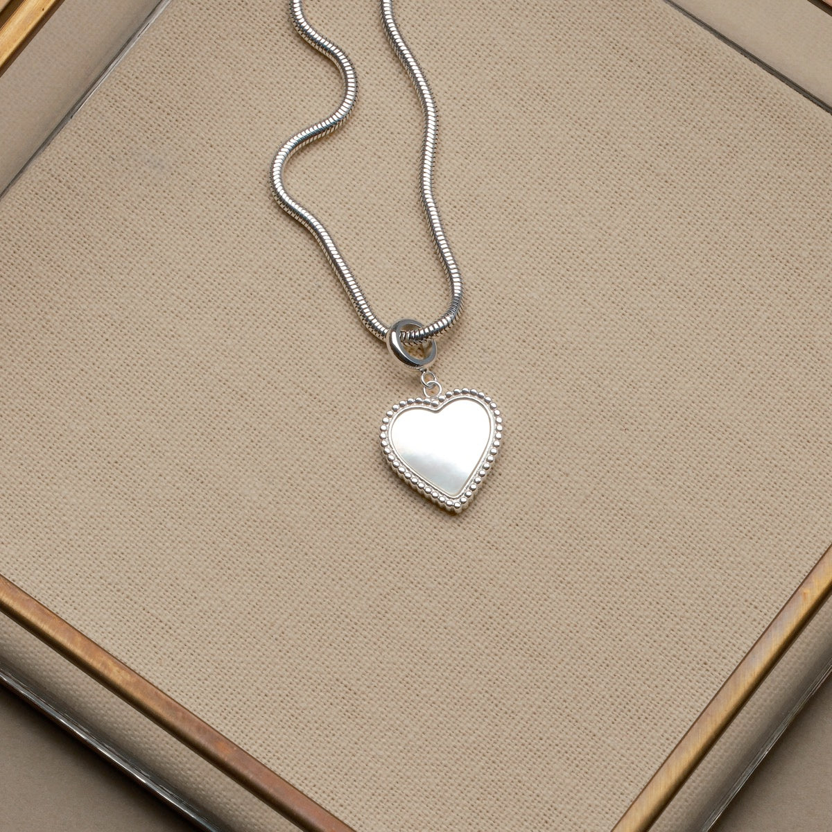 "Amorance Necklace" heart-shaped silver necklace with elegant, sleek design.