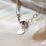 "Amorance Necklace" necklace with nacre and silver, featuring a sleek chain design on a shell backdrop.