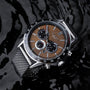 "Comfort Crusher" watch featuring a walnut dial and silver accents, stylishly designed against a reflective black surface.