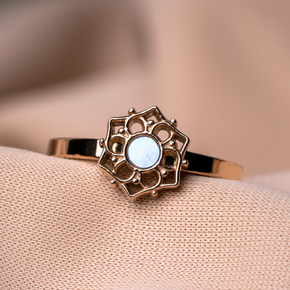 "Composition Ring": A delicate ring featuring a blue nacre center and rose gold detailing in a floral design.