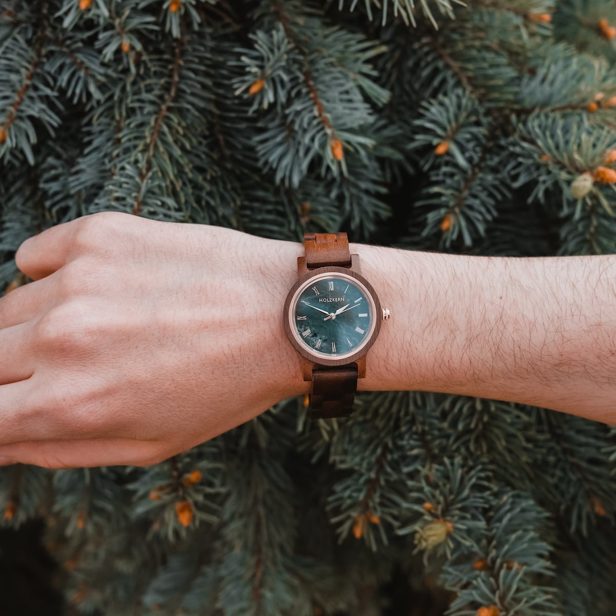 Montre "Nymph" avec bande de noyer et face en marbre, avec un design naturel élégant sur fond de pin.