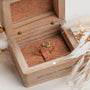 "Awakening Ring": elegante anillo con un diseño de mármol y oro, exhibido en una caja rústica.