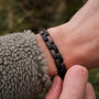"Rondo," een armband met een mix van esdoorn en antieke koper, die een rustiek, stijlvol design toont.