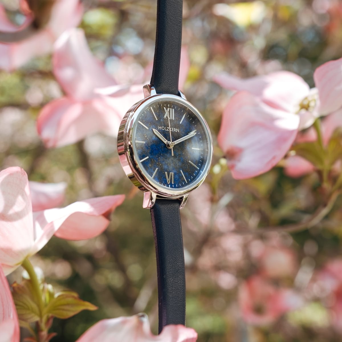 Montre "Teresa" avec une face lapis lazuli et des accents argentés au milieu de fleurs en fleurs.