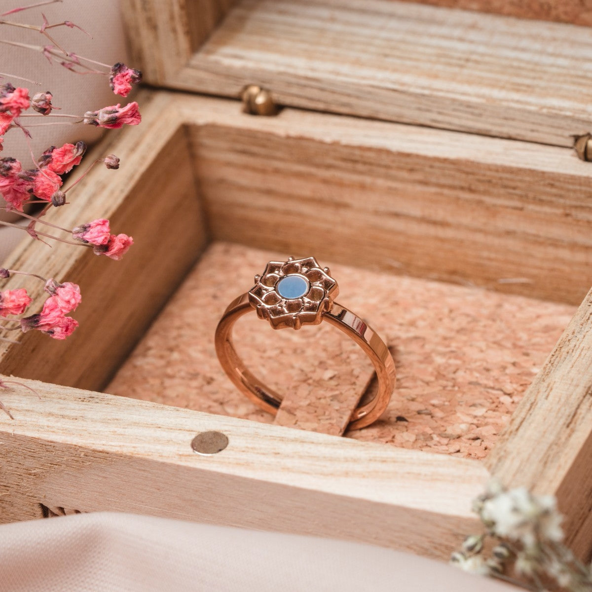 "Composition Ring", elegant ring featuring blue nacre and rose gold in a floral design, displayed in a wooden box.