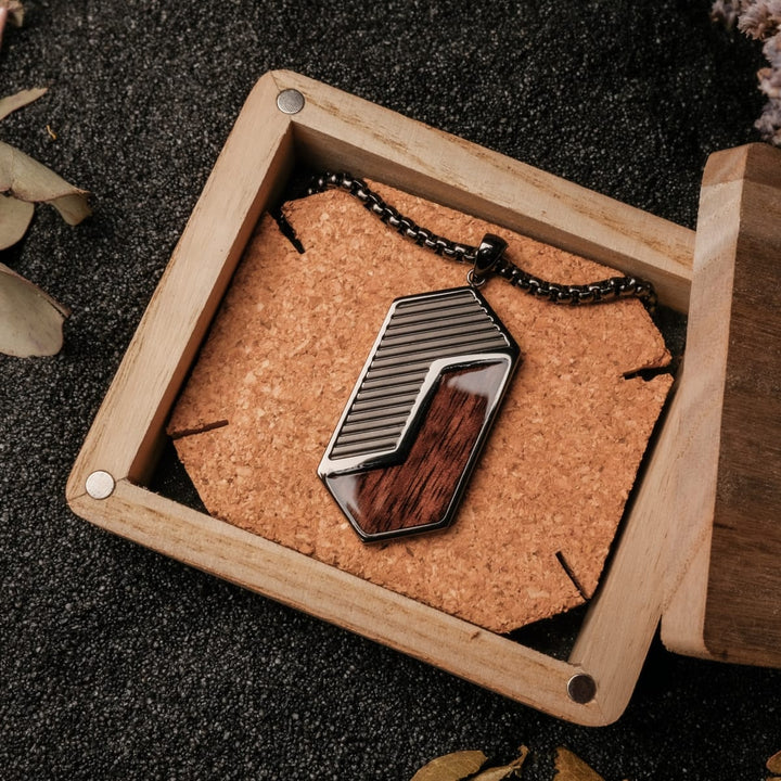 "Zigzag Necklace" necklace featuring a geometric design with walnut and dark grey accents, displayed in an open wooden box.