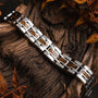 "Tremolo" bracelet, featuring a sleek walnut and silver design on a rustic wooden background.