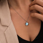 "Shade Necklace" necklace featuring a blue nacre pendant in a sunburst design with a silver chain.
