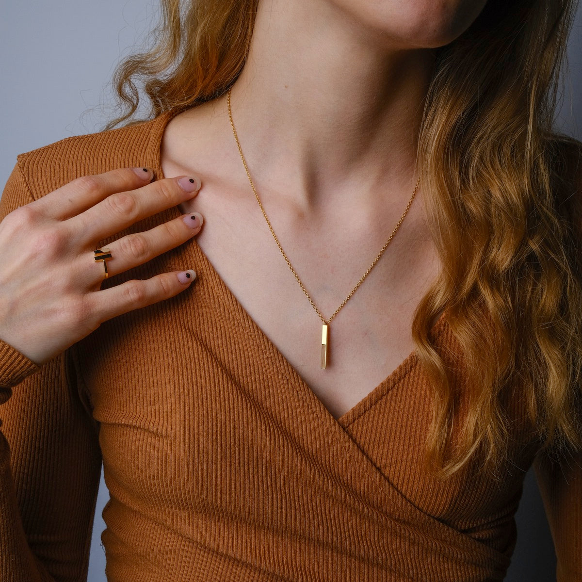 "Campania Ring" ring showcasing a sleek blend of koa wood and gold, worn on a hand with neutral-toned nails.