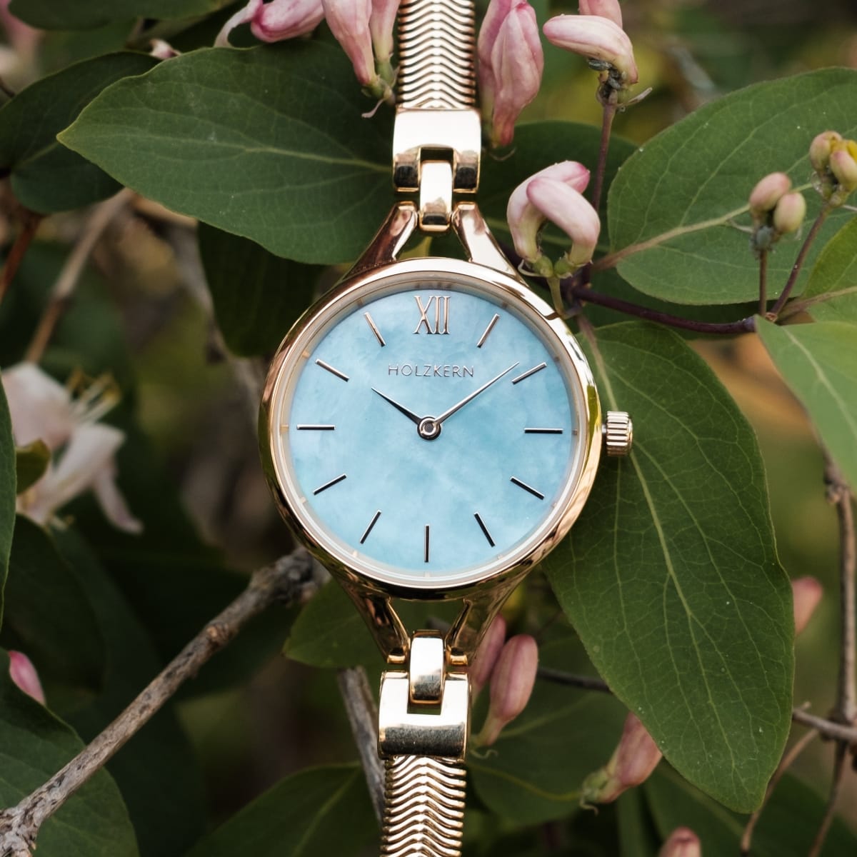 "Shesha" reloj con una cara de nacre y acentos de oro en un elegante entorno inspirado en la naturaleza.
