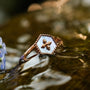 "Spectral Ring": A stylish ring with nacre and rose gold design featuring a floral motif and hexagonal setting.