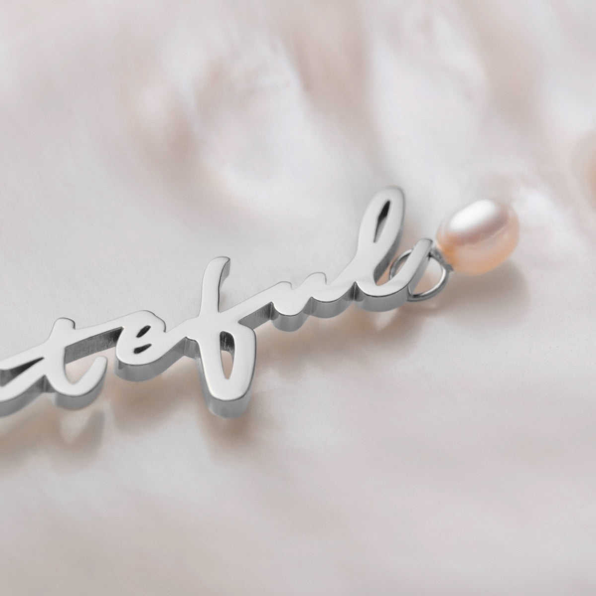 "Gratinal-Charm" vedhæng i elegant sølv script med en enkelt perle accent.