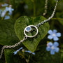 Bracelet en marbre et argent, élégant et élégamment exposé sur un feuillage vert vif.