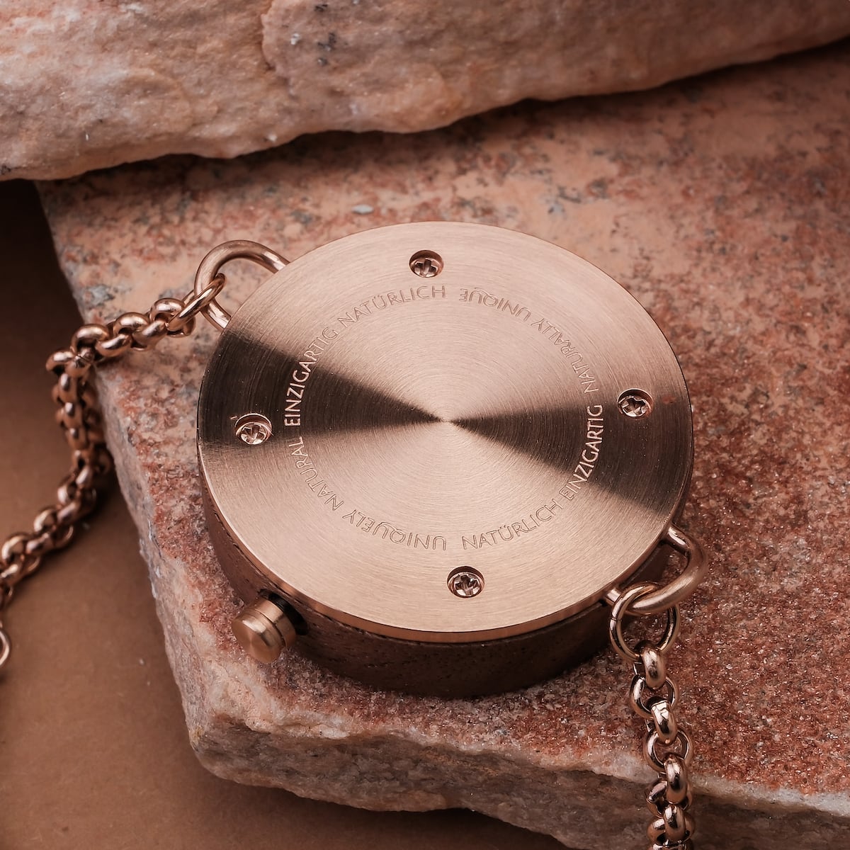 "Leave", un accessoire circulaire de style dans une finition noyer sophistiquée, avec des détails de chaîne métallique complexe.