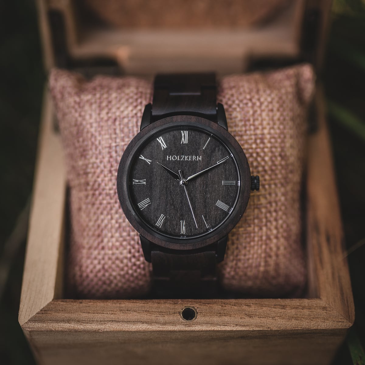 Montre "Carlos" dans une boîte en bois, avec une finition en bois foncé et un design minimaliste.