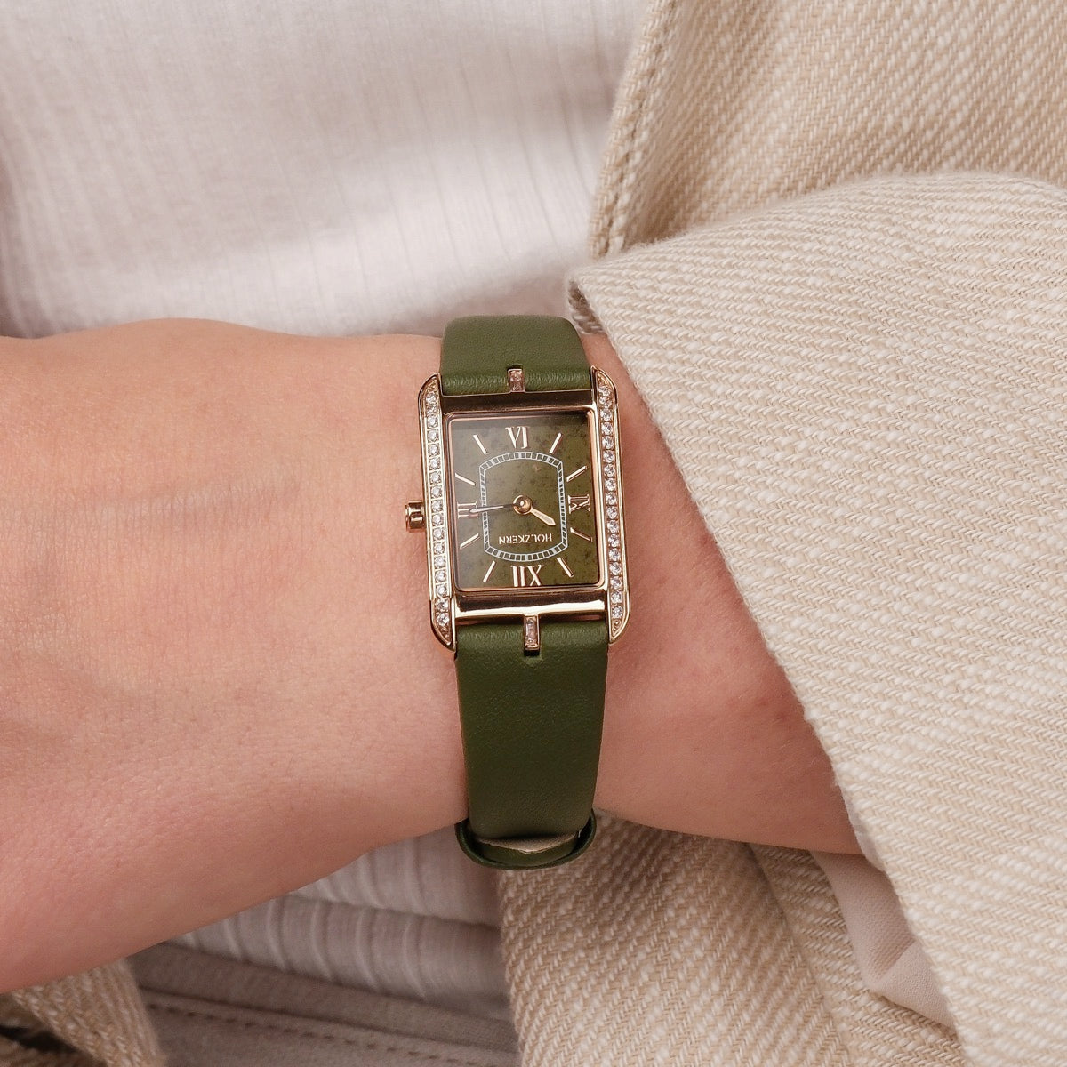 "Memoire" watch with a green leather strap and rectangular dial, showcasing elegant and stylish design.