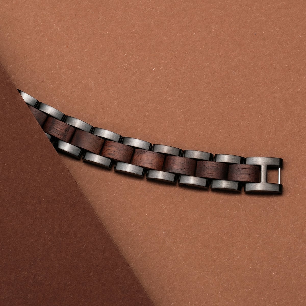 "Triad" watch strap in walnut and grey, showcasing a sleek, modern design with rich wood accents.